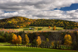 Isolated farmhouse among forest trees in Fall color on Blue Mountain Vermont