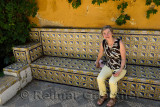 Tired female tourist sitting on tiled bench at Calle Antonio el Balarin Seville Spain