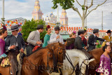 Group of couples on horseback drinking and partying at the Seville April Fair with Casetas and Main Gate