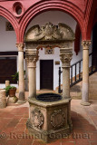 Stone well with pillars in the entrance courtyard of Mondragon Palace and Ronda Museum Andalusia