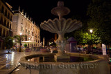 Fountain in Plaza Nueva at night with Royal Chancery of Granada and church of Santa Ana
