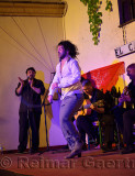 Hot male Flamenco dancer swinging tie on stage at night in an outdoor courtyard in Cordoba Spain
