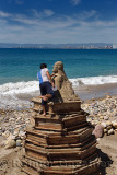 Mexican artist standing on forms while carving a sand sculpture on the beach at Malecon Puerto Vallarta