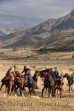 Rider on horse reaching down to pick up goat carcass in game of Kokpar Tudabarai in Aksu Zhabagly Kazakhstan