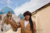 Great Horned Owl and handler with domes of Khoja Ahmed Yasawi mausoleum Turkestan Kazakhstan
