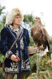 Trainer in traditional clothes holding a White Tailed Eagle at Sunkar Falcon Farm Almaty Kazakhstan
