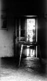 Trough The Door: A Table And No Chairs. A Lamp B&W