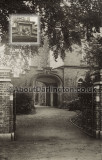 House with a cockerel family crest above the archway
