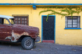 Old car yellow house