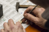 Her viser han hvordan han simulerer nagler. Litt metallplate klipt ut fra en sigarhylse, lagt flatt p en trebit.