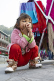 a 3-year old girl keeps an eye on her merchandise 