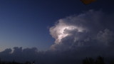 Lightning illuminating dense storm clouds high above Es Calo