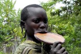 Surma woman with an extremely big lip plate and stretched ear lobes for plates; south-western Ethiopia.