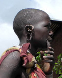 Surma woman with scarification marks and streched lower lip and ear lobes for plates;  south-western Ethiopia.