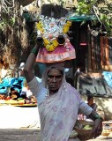 Devotee carrying a basket containing a brass bust of Yellamma, Yellamma temple,  Saundatti, Karnataka, India