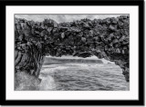 Arch out of basaltic rocks carved by waves