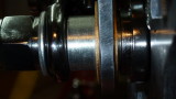 A large bushing goes against the bearing and the caliper slides over it with 2 brass bushings either side. 