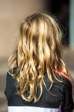 Blonde little girl watching busker
