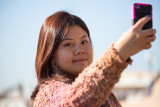 Young Asian girl with iPhone taking her picture