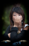 Young Asian woman with hand on face