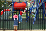 A child in pink hat watching children play