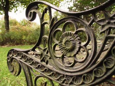 Weathered wrought iron bench arm