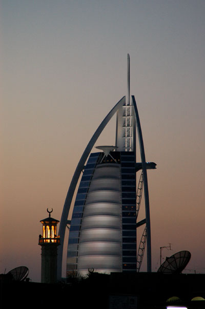 Lighted minaret and the Burj Al Arab at dusk