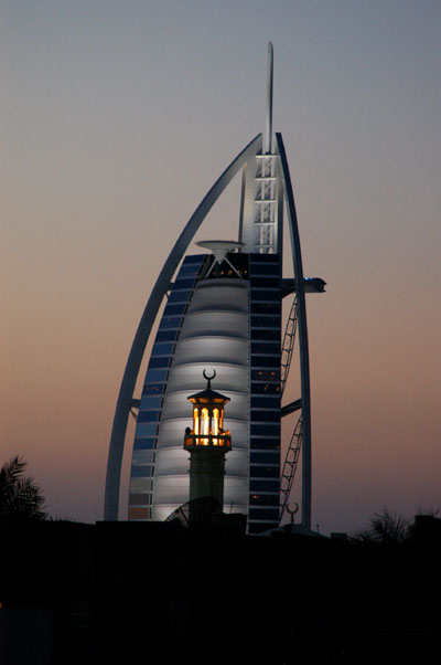 Lighted minaret and the Burj Al Arab at dusk