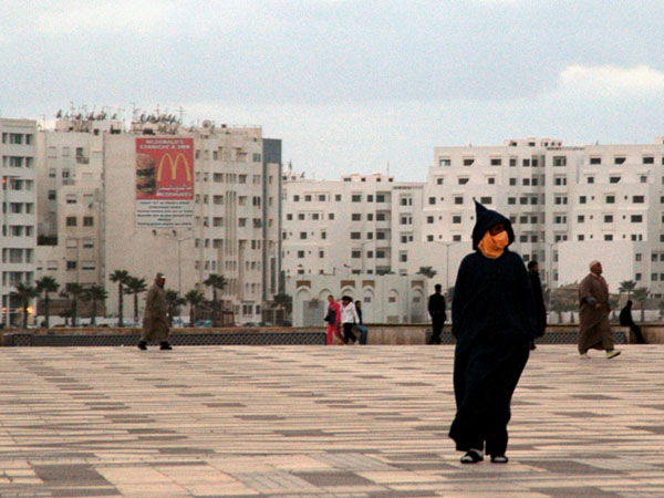 Man in a Jallaba walking on the Hassan II Mosque square