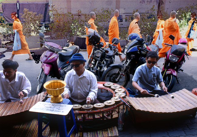  Monks passing behind blind musicians near the amulet market.