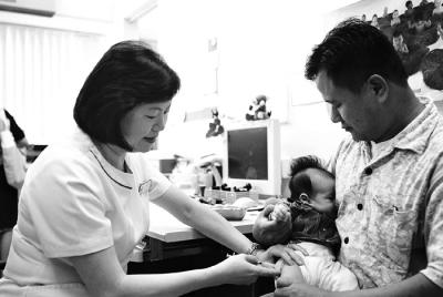 Community Nurse Innoculating Baby