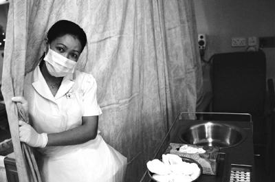 Nurse Screening Patient's Bed