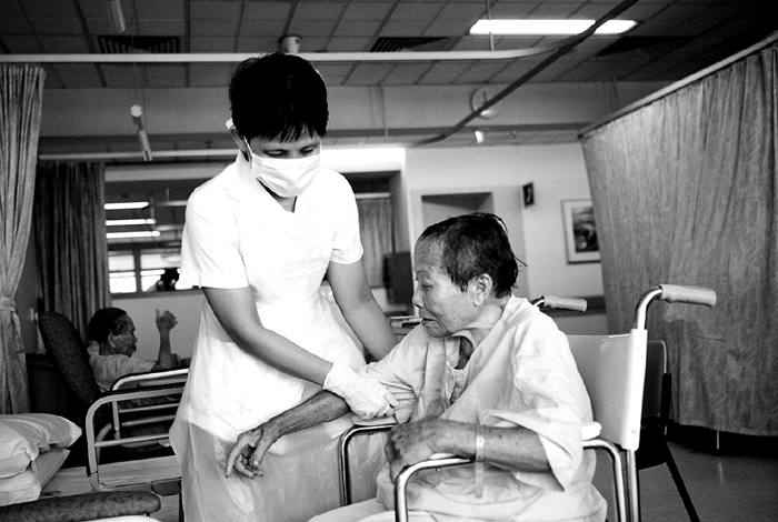 Nurse Bringing Elderly to Bed
