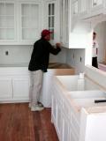 An installer works on the custom cabinets