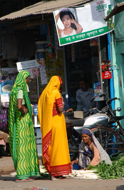 Women in saris and a vegetable vendor