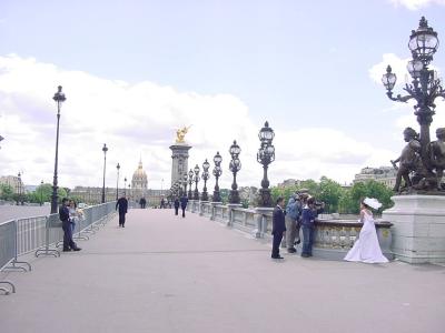 A bride is photographed on the Pont Alexandre III bridge.