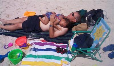 Ok, I can avoid the sand if I lay on Daddy!