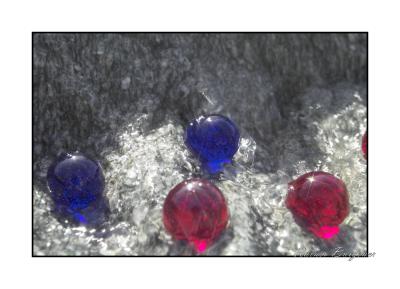 8-star blue and red marbles in water on granite