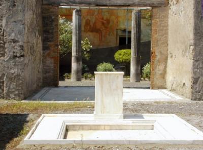 Pompeii -  The entrance to the House of the Vettii. An erotic fresco is in the background.
