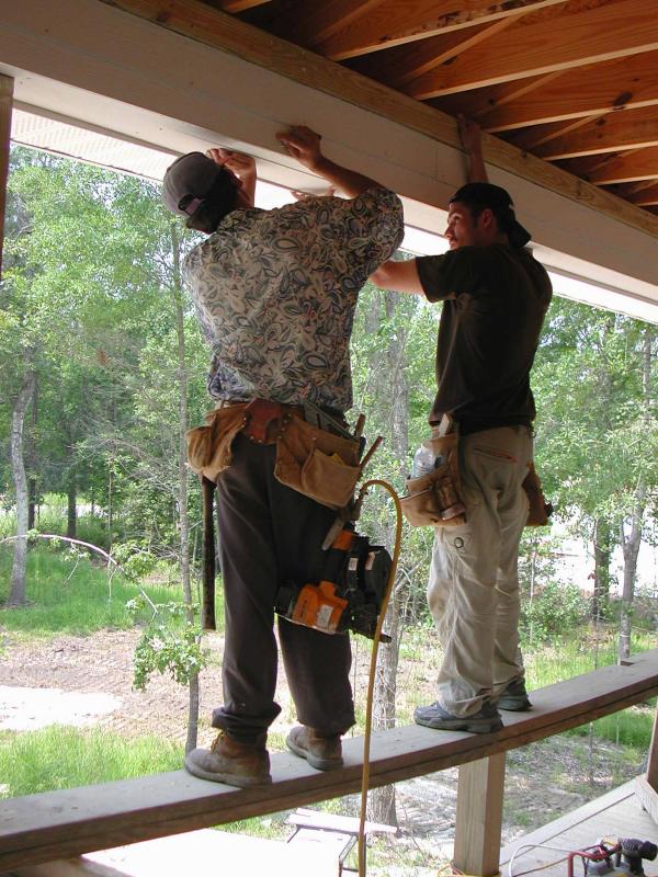 Carpenters work on the front porch trim