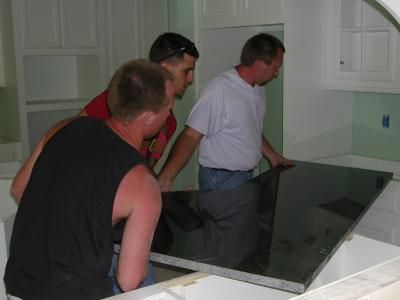 One of the large granite slabs is lifted into place