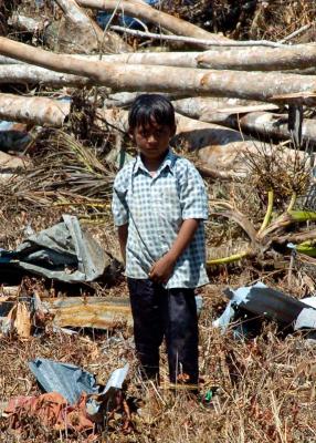 child stands amid the destruction