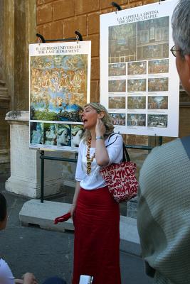Tour guide of the Vatican Museum in the Courtyard of the Pigna, explaining the interior of the Sistine Chapel.
