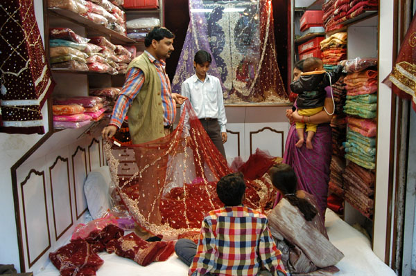 Salesman showing a sari, Old Delhi