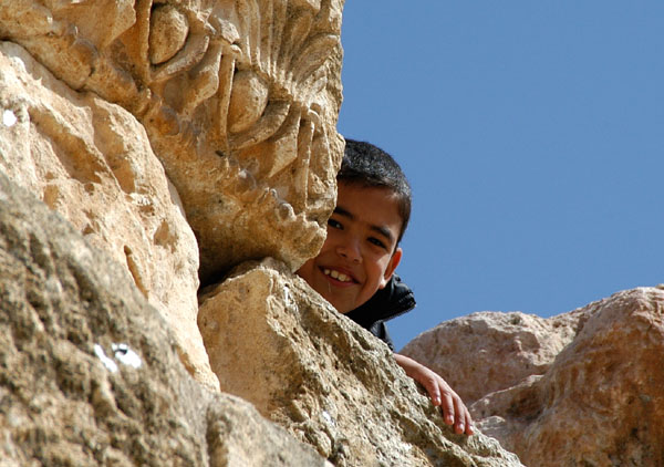 Jordanian schoolboy peeks out from the ruins, Jerash