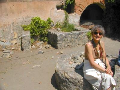 Pompeii - Judy in a pistrinum (bakery). The oven is in the background.