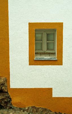 Yellow window, white wall, steep street