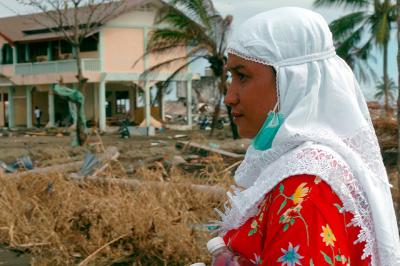 Indonesian woman watches as relief supplies come in