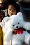 Indonesian girl clasps teddy bear