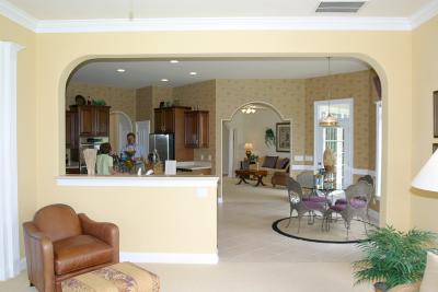 View of edge of family room and then the kitchen and breakfast nook from the family room. You can see the formal living room straight ahead in the back of the picture. A door slightly to the right of center leads to the covered patio.